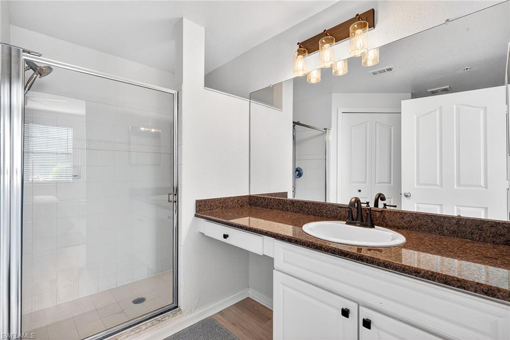 12950 Positano Circle, Unit 101 Naples, FL 34105 - Photo 17 of 34 a bathroom with a sink and a mirror