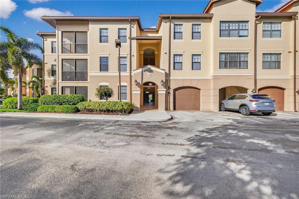 12950 Positano Circle, Unit 101 Naples, FL 34105 - Photo 2 of 34 a front view of a house with a yard