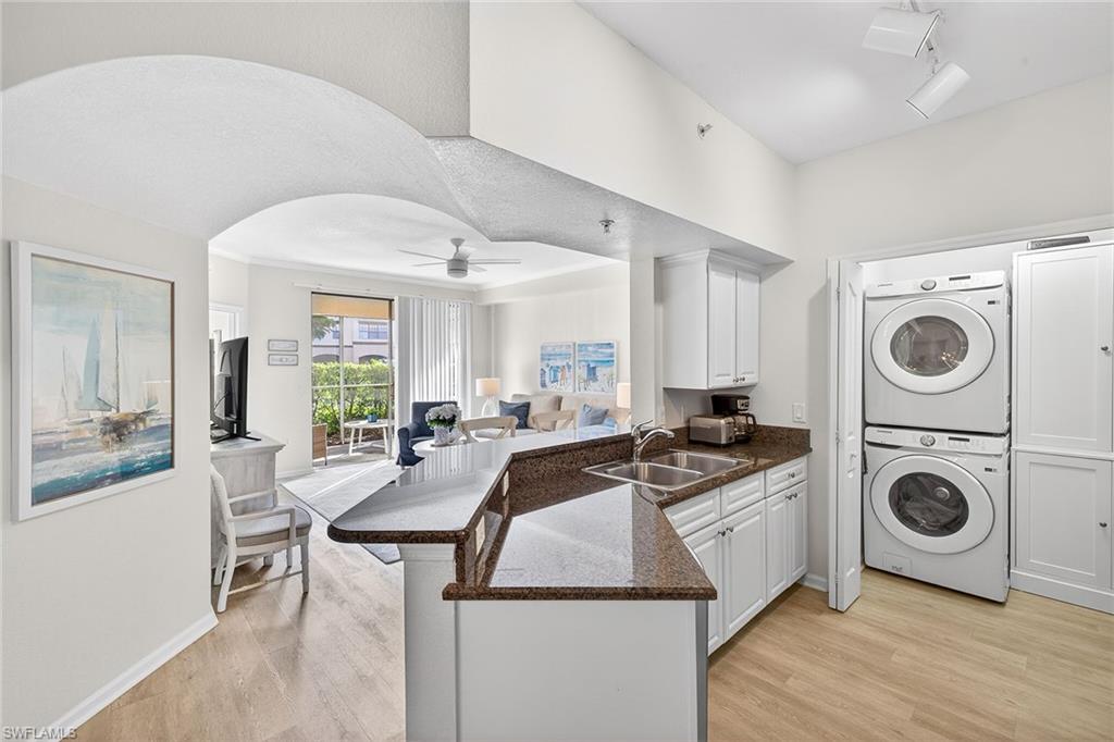 12950 Positano Circle, Unit 101 Naples, FL 34105 - Photo 22 of 34 a kitchen with a stove sink and cabinets
