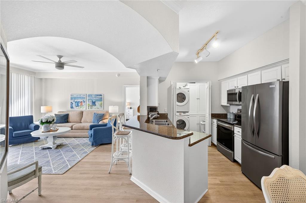 12950 Positano Circle, Unit 101 Naples, FL 34105 - Photo 23 of 34 a living room with furniture kitchen view and a refrigerator