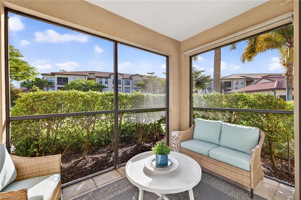 12950 Positano Circle, Unit 101 Naples, FL 34105 - Photo 25 of 34 a living room with furniture and a large window