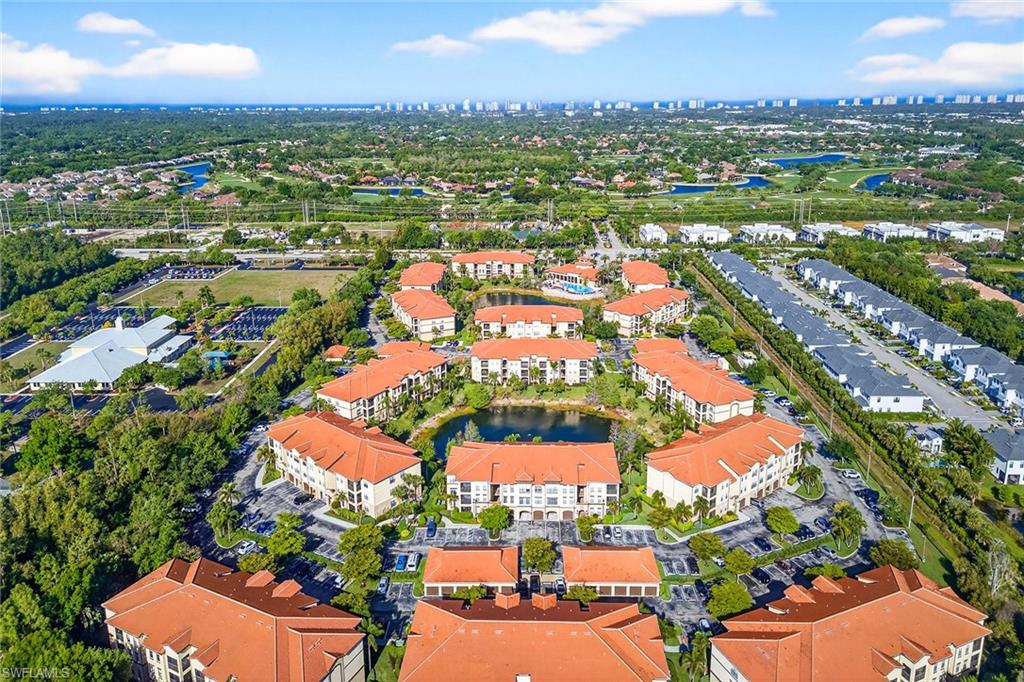 12950 Positano Circle, Unit 101 Naples, FL 34105 - Photo 31 of 34 an aerial view of residential houses with outdoor space and trees