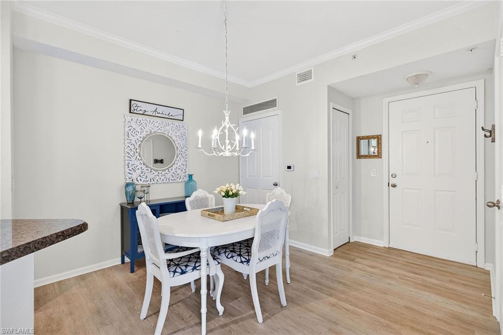 12950 Positano Circle, Unit 101 Naples, FL 34105 - Photo 7 of 34 a view of a dining room with furniture and wooden floor