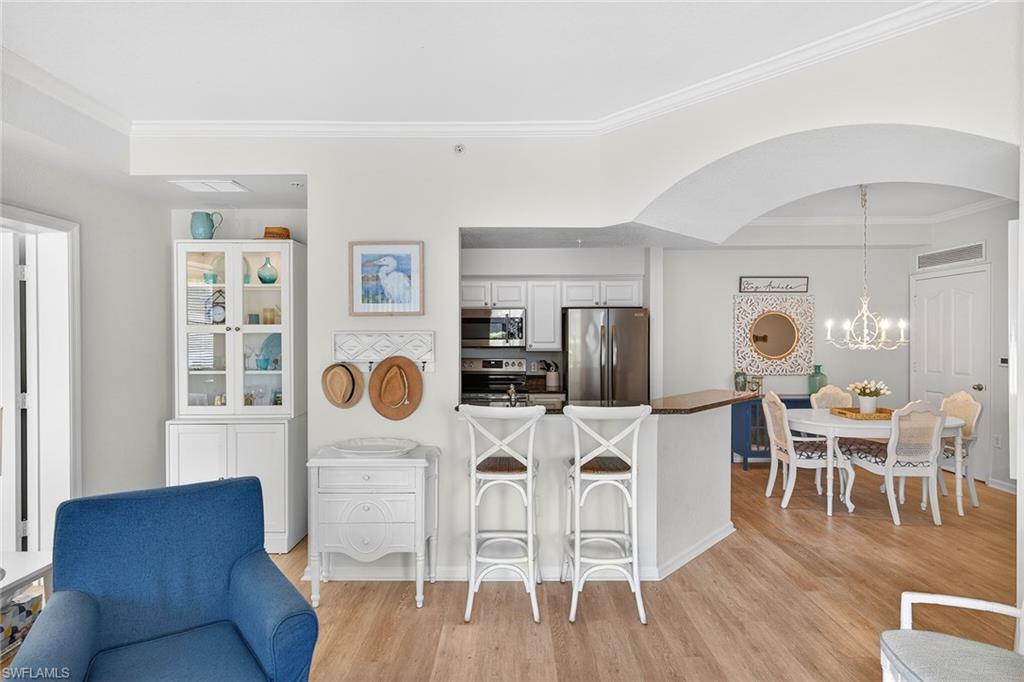 12950 Positano Circle, Unit 101 Naples, FL 34105 - Photo 8 of 34 a living room with furniture a wooden floor and next to a window
