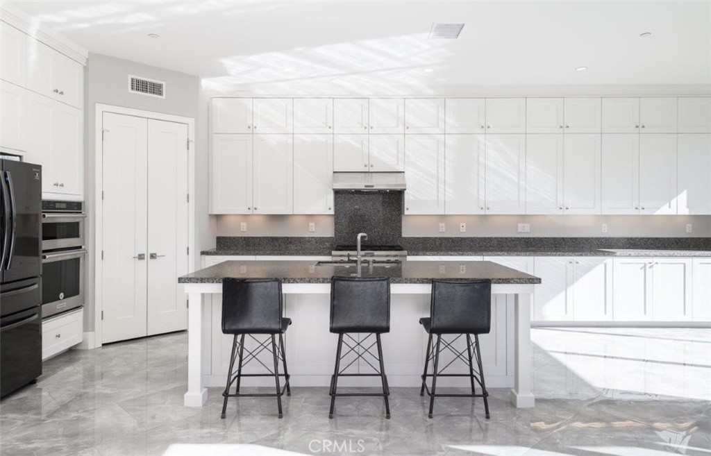 100 Rusina Irvine, CA 92602 - Photo 11 of 46 a kitchen with a cabinets and chairs