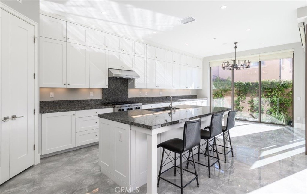 100 Rusina Irvine, CA 92602 - Photo 12 of 46 a kitchen that has a lot of white cabinets and stainless steel appliances