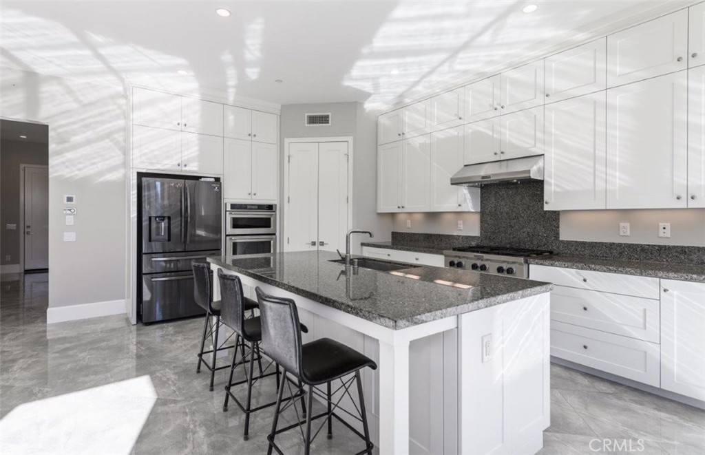 100 Rusina Irvine, CA 92602 - Photo 18 of 46 a kitchen with stainless steel appliances granite countertop a stove a sink and a refrigerator