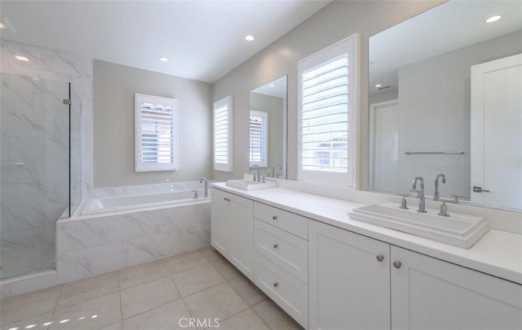 100 Rusina Irvine, CA 92602 - Photo 26 of 46 a bathroom with a granite countertop sink mirror and a bathtub