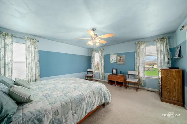 a spacious bedroom with a bed and a chandelier