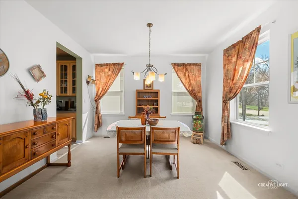 a dining room with furniture window wooden floor and a chandelier