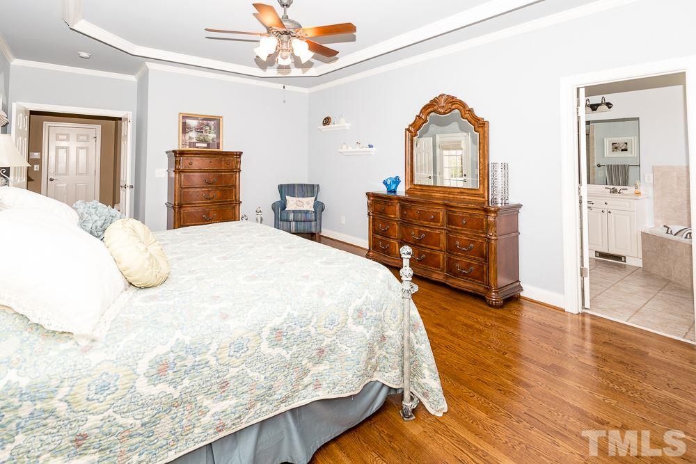 5109 Indigo Moon Way Raleigh, NC 27613 - Photo 13 of 24 a bedroom with a bed and dresser with mirror