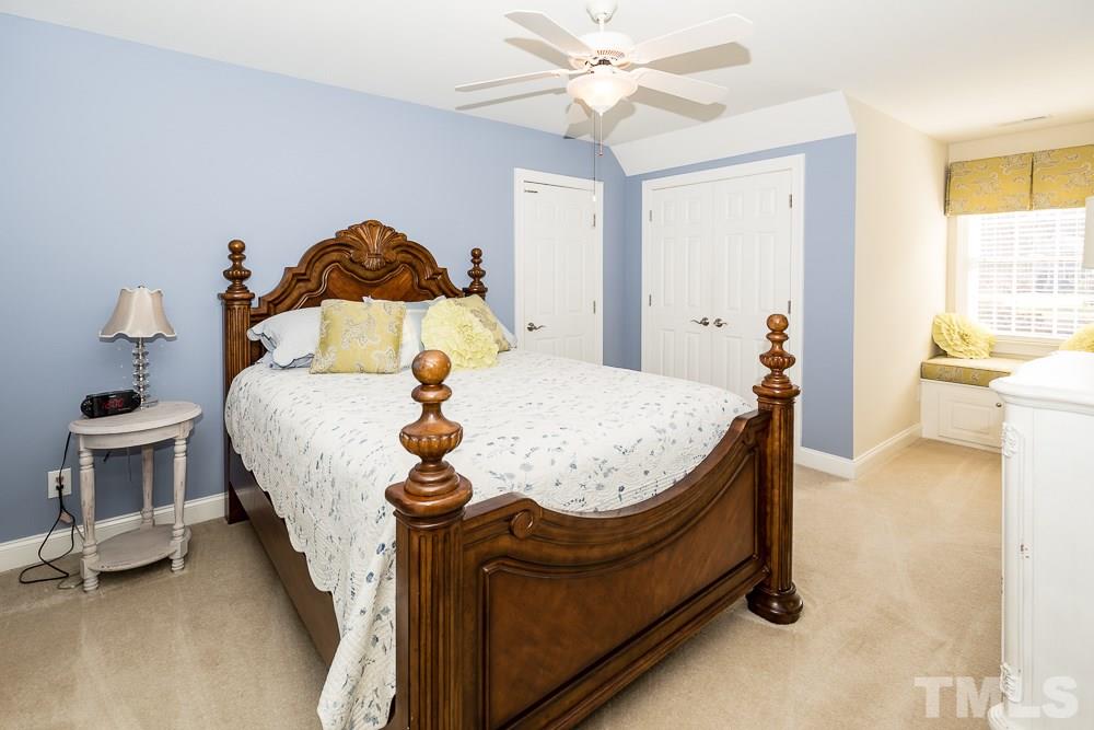 5109 Indigo Moon Way Raleigh, NC 27613 - Photo 20 of 24 a bedroom with a bed and a chandelier