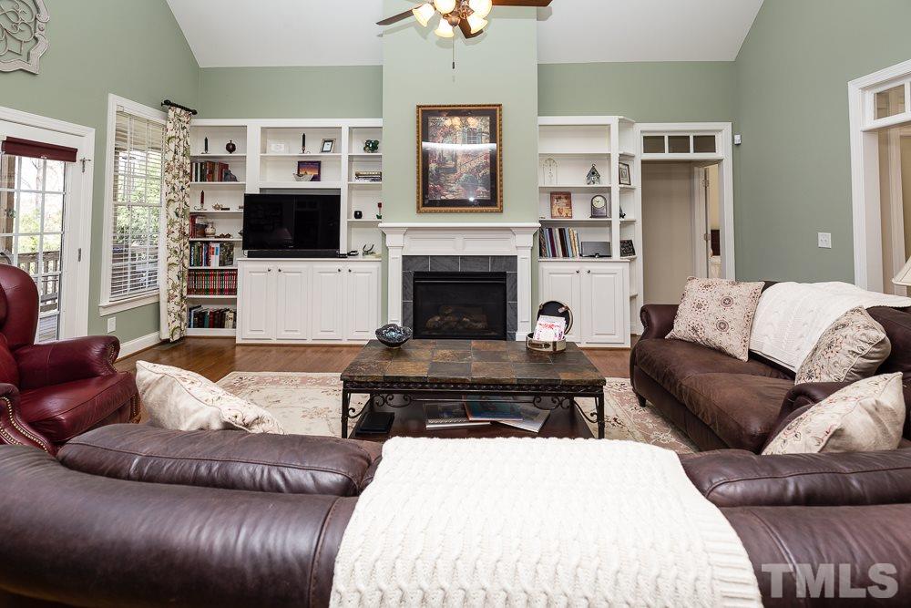 5109 Indigo Moon Way Raleigh, NC 27613 - Photo 6 of 24 a living room with furniture a flat screen tv and a fireplace