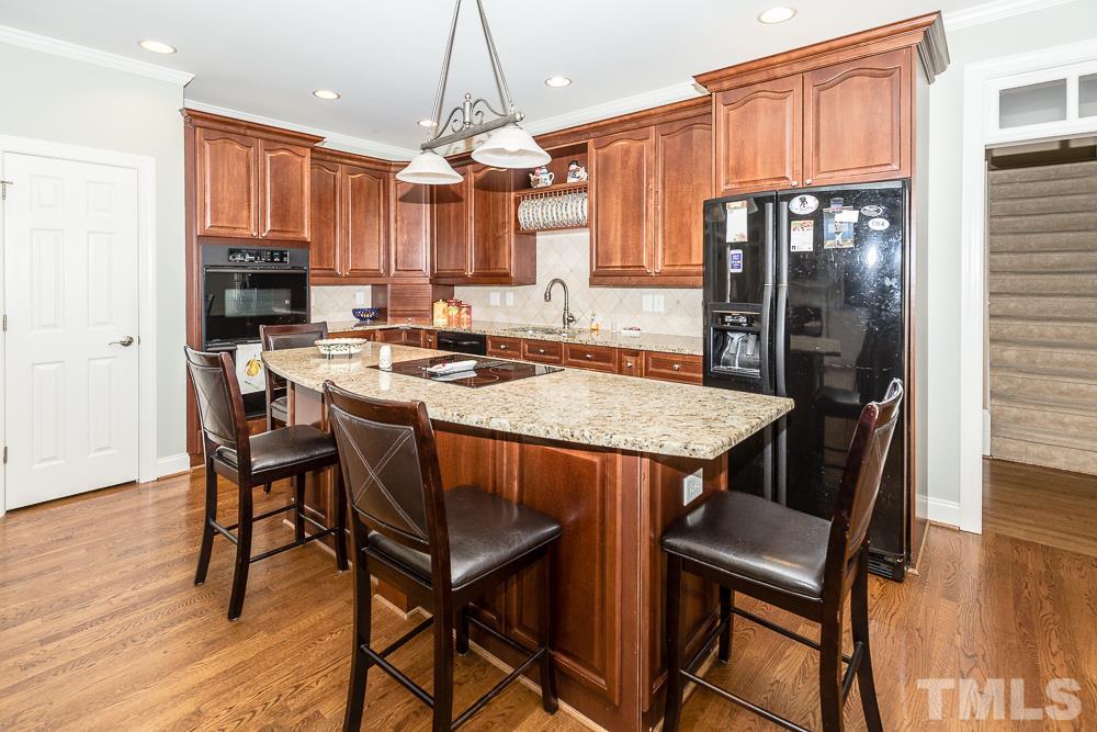5109 Indigo Moon Way Raleigh, NC 27613 - Photo 8 of 24 a kitchen with a table chairs refrigerator and cabinets