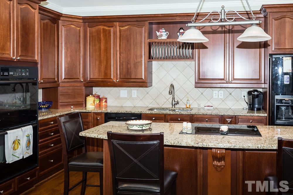 5109 Indigo Moon Way Raleigh, NC 27613 - Photo 9 of 24 a kitchen with granite countertop a sink a stove and cabinets