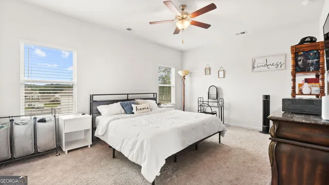 a bedroom with a bed flat screen tv and a window