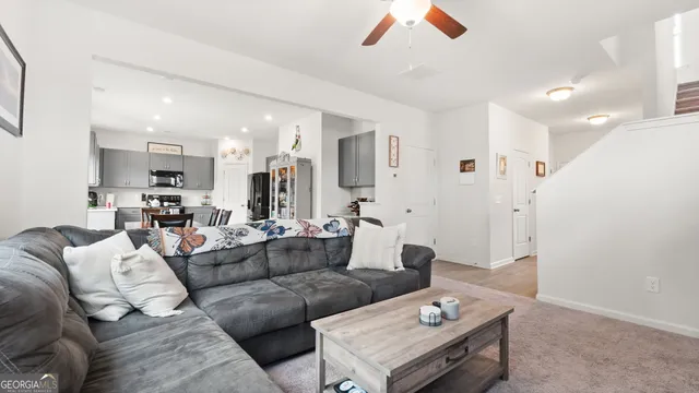 a living room with furniture and a dining table with kitchen view