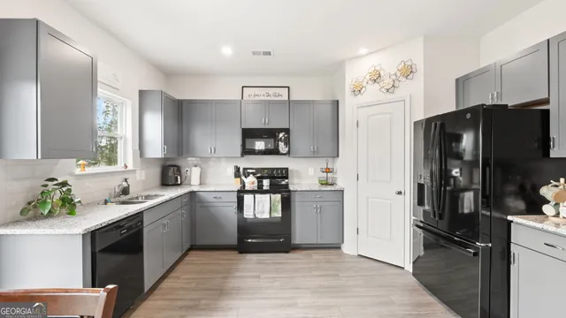 a kitchen with granite countertop a refrigerator stove and sink