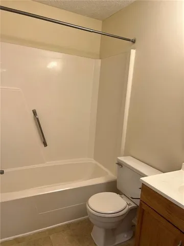 a white toilet sitting next to a bath tub