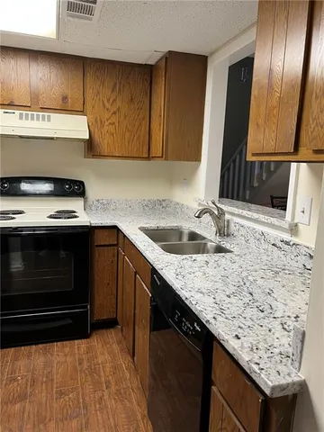 a kitchen with granite countertop stainless steel appliances and wooden cabinets