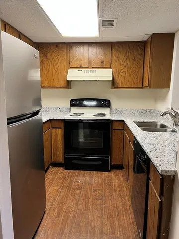 a kitchen with stainless steel appliances granite countertop a stove a refrigerator and a sink