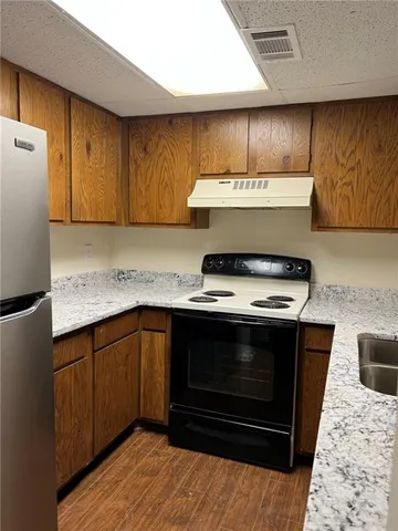 a kitchen with granite countertop a stove and a sink