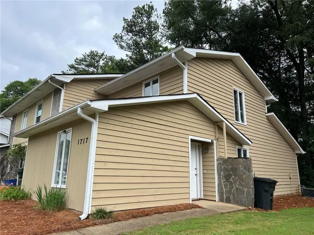 a view of house with a yard and garage