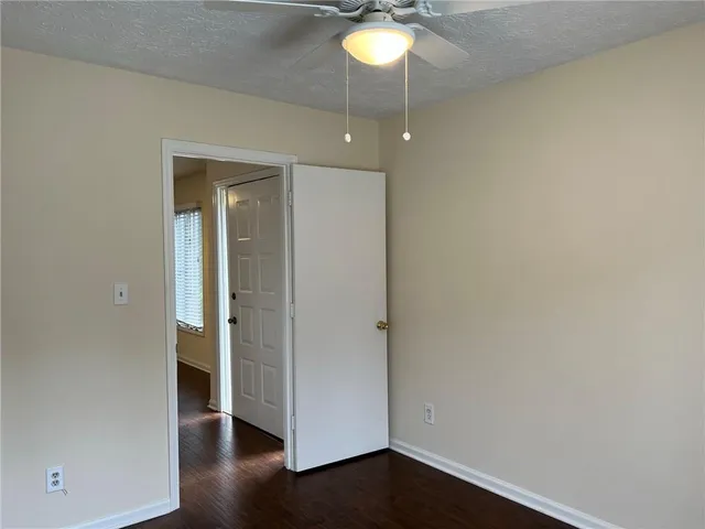 an empty room with wooden floor and ceiling fan