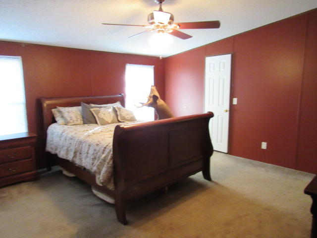 7450 Old River Road Baker, FL 32531 - Photo 12 of 26 a bed room with a bed and a chandelier