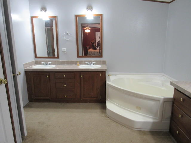 7450 Old River Road Baker, FL 32531 - Photo 13 of 26 a bathroom with a tub sink and mirror