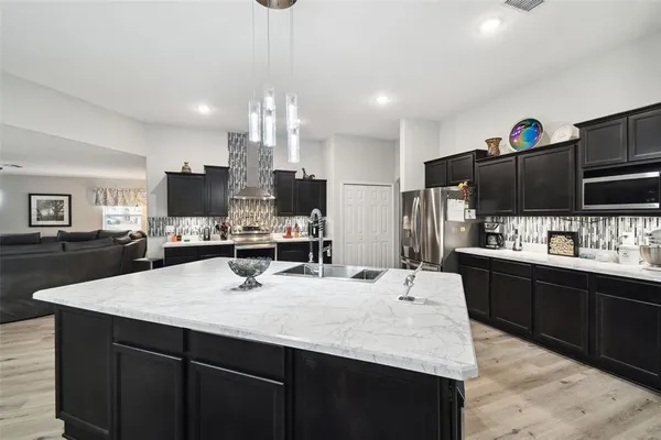 a large kitchen with stainless steel appliances kitchen island granite countertop a sink counter space and cabinets