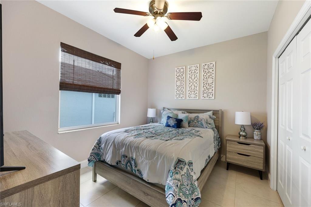 697 Crossfield Circle Naples, FL 34104 - Photo 14 of 18 Bedroom with light tile patterned flooring, a closet, and a ceiling fan