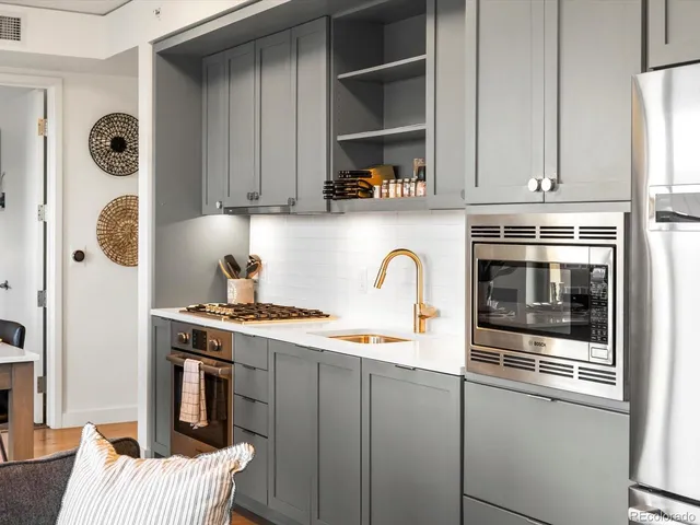 a kitchen with stainless steel appliances granite countertop a stove a sink and a refrigerator