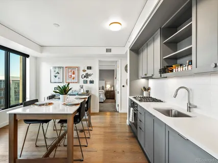 a kitchen with stainless steel appliances a table and chairs in it