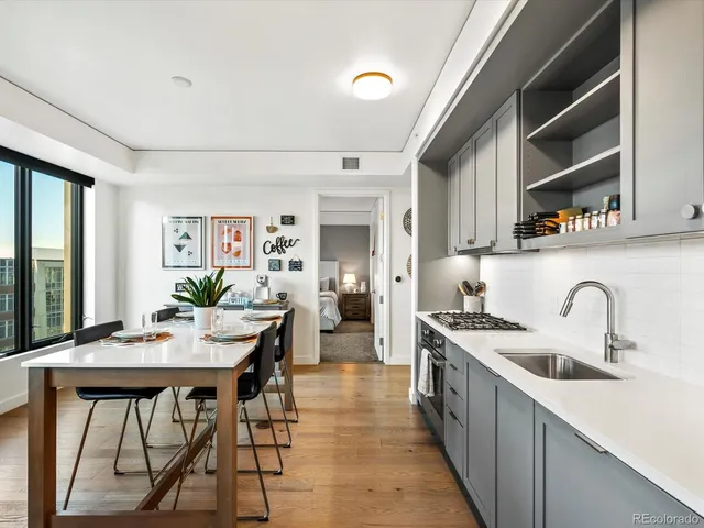 a kitchen with stainless steel appliances a table and chairs in it