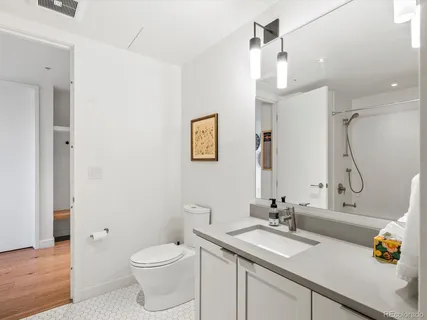 a bathroom with a sink vanity granite toilet and a mirror