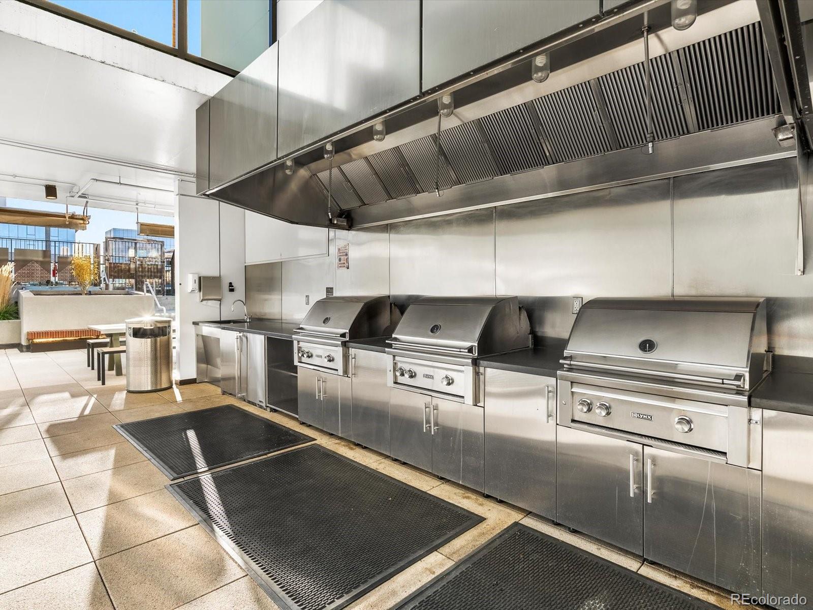 1750 Wewatta Street, Unit 1409 Denver, CO 80202 - Photo 34 of 48 a kitchen with stainless steel appliances granite countertop a sink a stove and cabinets