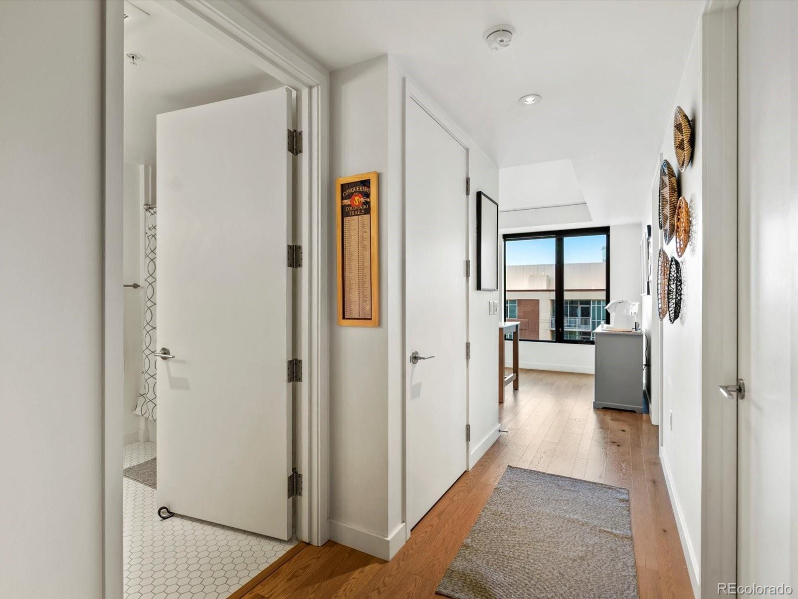 1750 Wewatta Street, Unit 1409 Denver, CO 80202 - Photo 7 of 48 a view of a hallway with wooden floor and a living room
