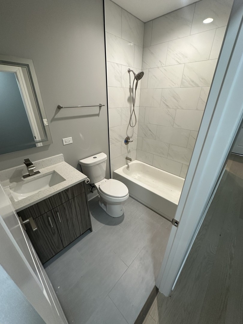 4950 South Michigan Avenue, Unit 2 Chicago, IL 60615 - Photo 13 of 13 a bathroom with a sink a toilet and shower