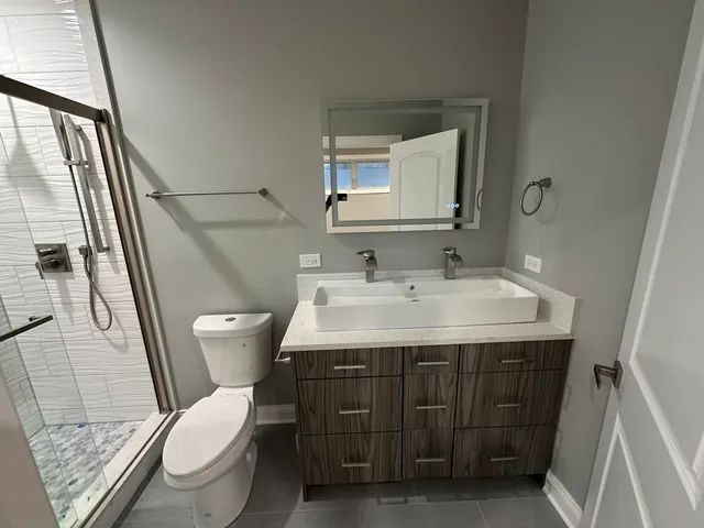 a bathroom with a sink vanity mirror and toilet