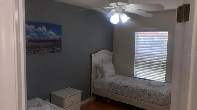 a view of a livingroom with a chandelier fan and a window