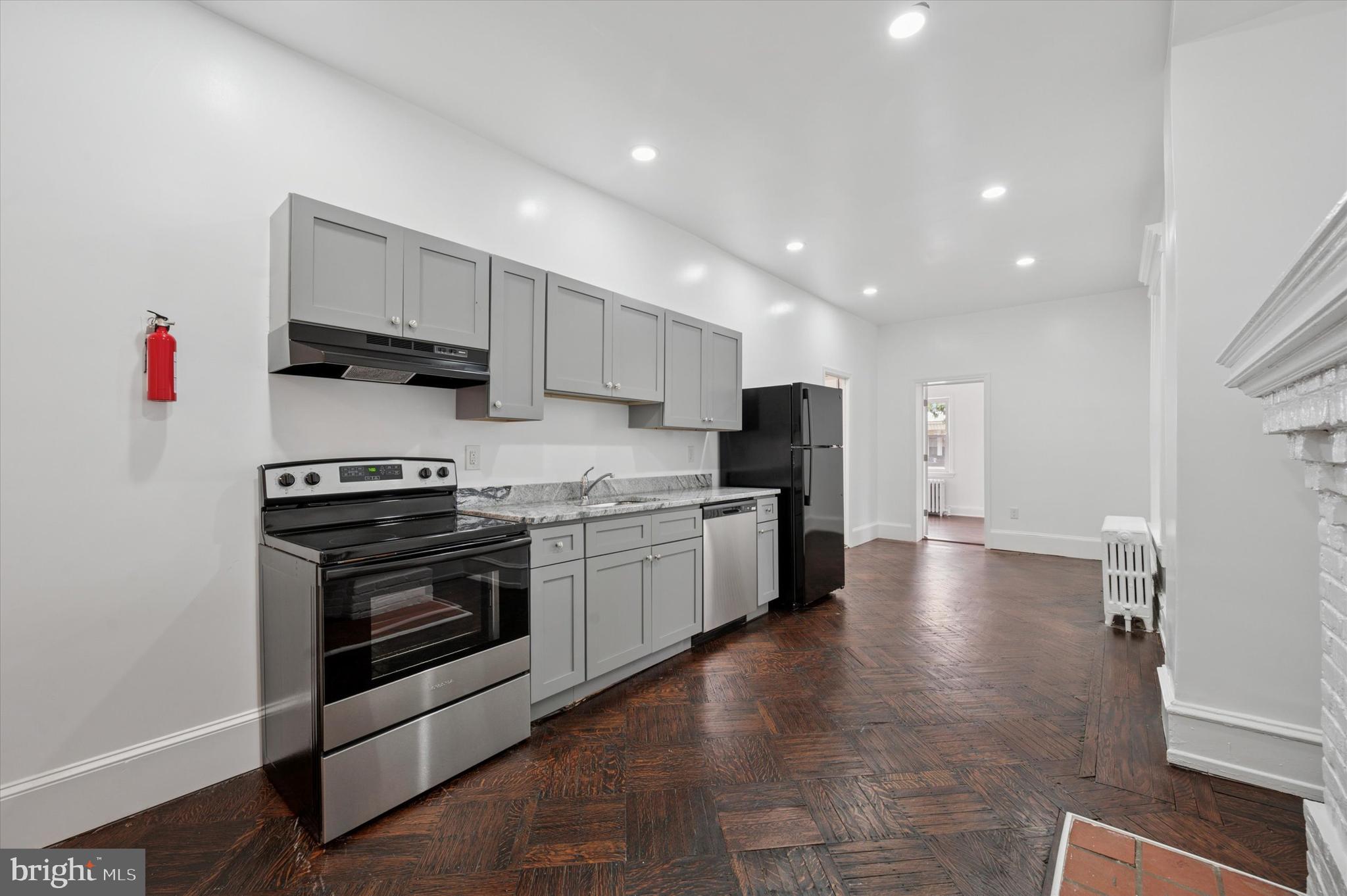 4928 Walnut Street, Unit 1 Philadelphia, PA 19139 - Photo 1 of 7 a kitchen with stainless steel appliances a stove a sink and a refrigerator