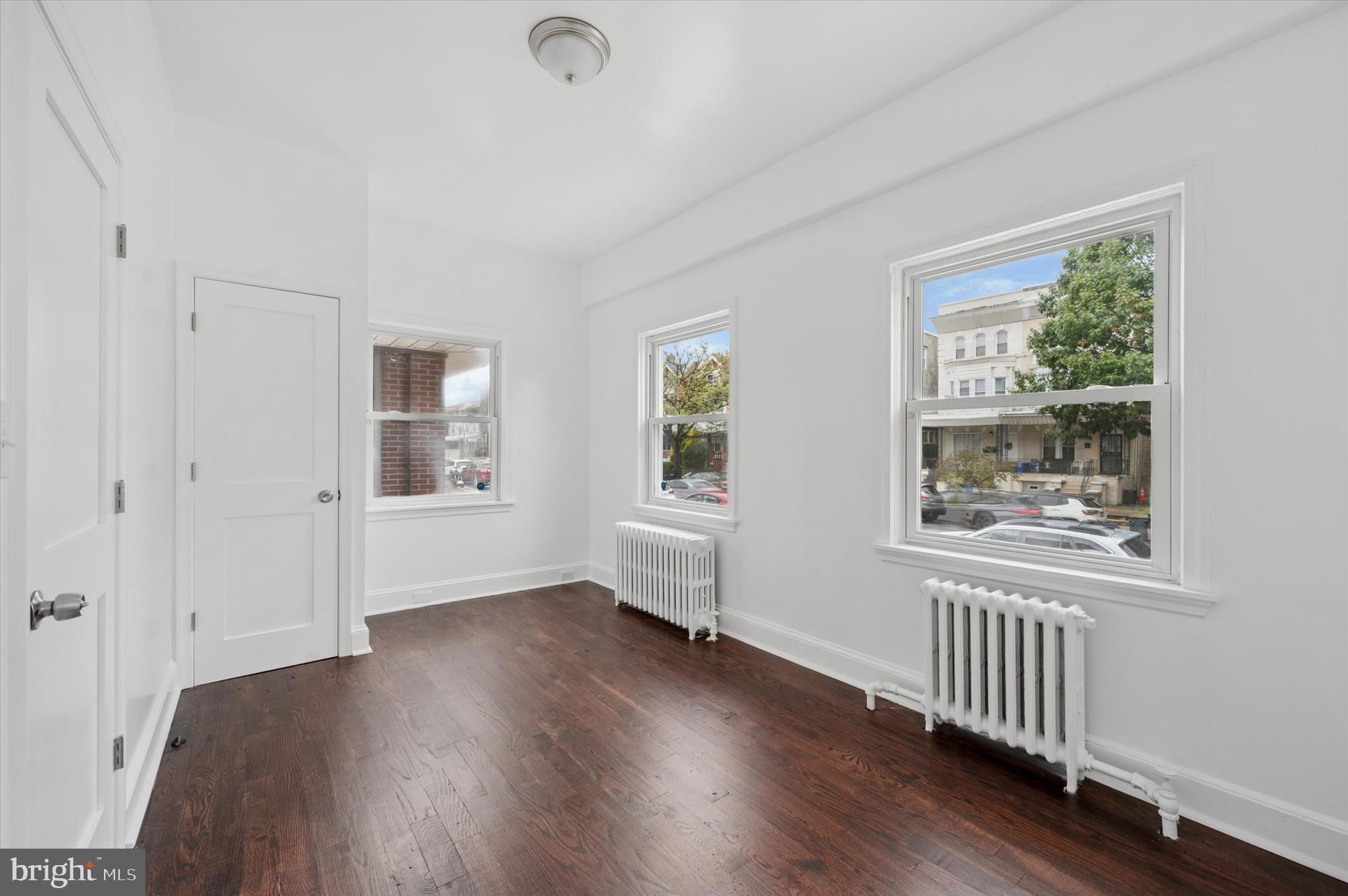 4928 Walnut Street, Unit 1 Philadelphia, PA 19139 - Photo 4 of 7 an empty room with wooden floor and windows