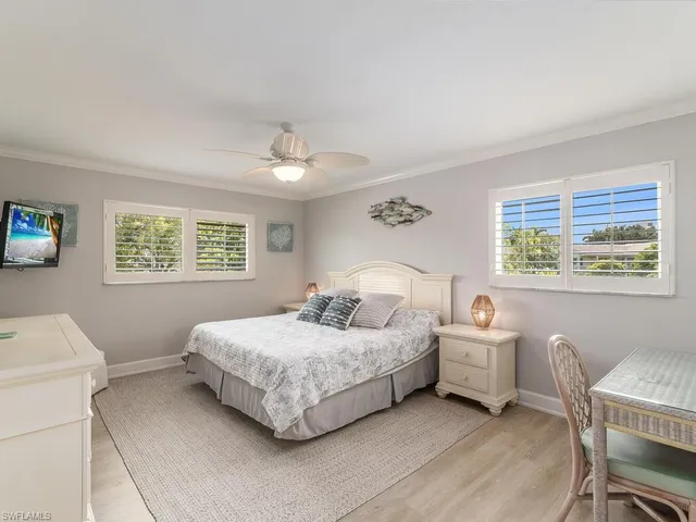 a bedroom with a bed and a table in it with window