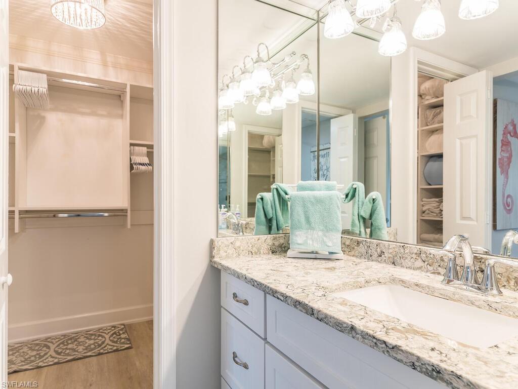 4180 Crayton Road, Unit E7 Naples, FL 34103 - Photo 14 of 35 a bathroom with a granite countertop sink and a mirror