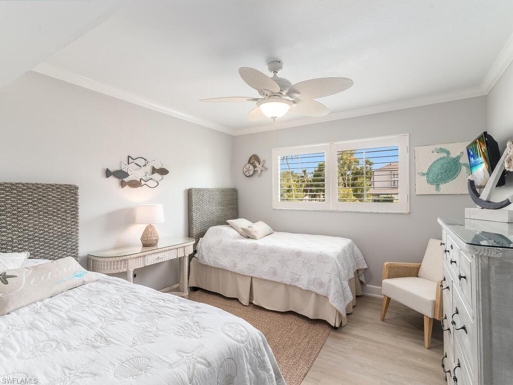 4180 Crayton Road, Unit E7 Naples, FL 34103 - Photo 17 of 35 a bedroom with two beds and a large mirror