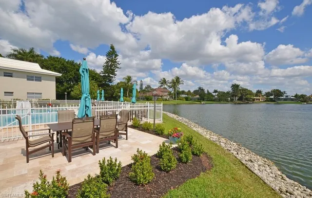 a view of a lake with table and chairs