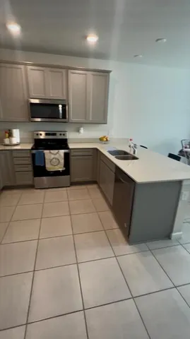 a kitchen with stainless steel appliances a sink a stove a microwave and cabinets