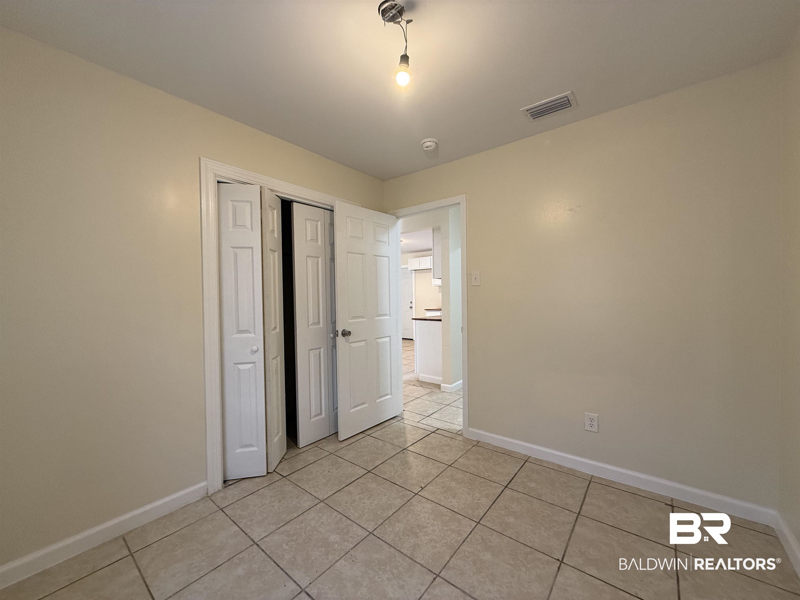 320 E Street Prichard, AL 36610 - Photo 13 of 16 Unfurnished bedroom with a closet and light tile patterned floors