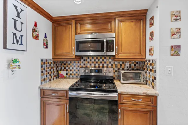 a kitchen with granite countertop cabinets stainless steel appliances and wooden floor